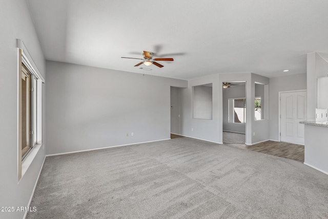 unfurnished living room with carpet floors and ceiling fan