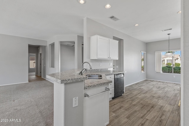 kitchen featuring black dishwasher, decorative light fixtures, light stone countertops, white cabinets, and sink