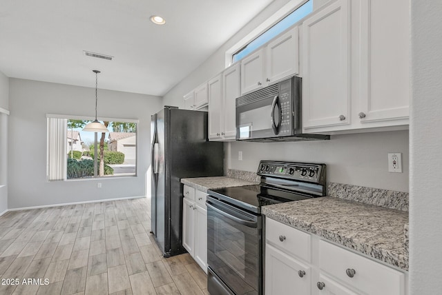 kitchen featuring black appliances, hanging light fixtures, light wood-type flooring, white cabinets, and light stone counters