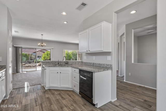 kitchen with light stone counters, sink, white cabinetry, and black dishwasher