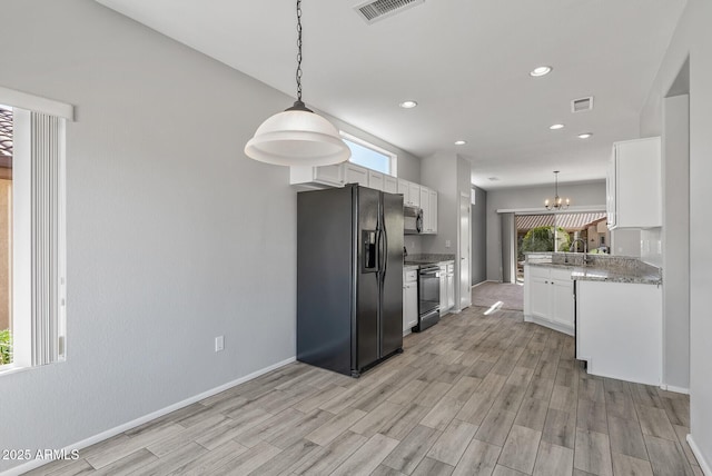 kitchen featuring light wood-type flooring, hanging light fixtures, light stone countertops, white cabinets, and black appliances