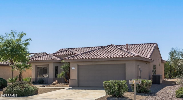 mediterranean / spanish house featuring a garage and central AC unit