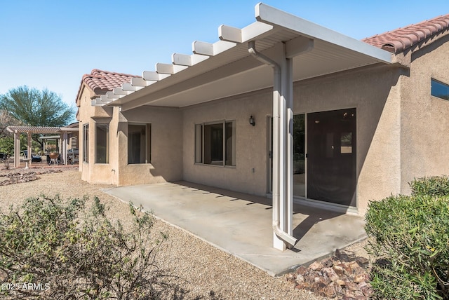 back of property with a pergola and a patio area