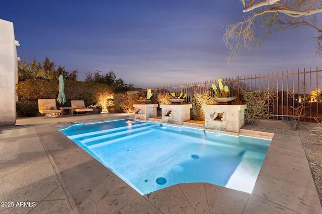 pool at dusk featuring a patio area and a fenced backyard