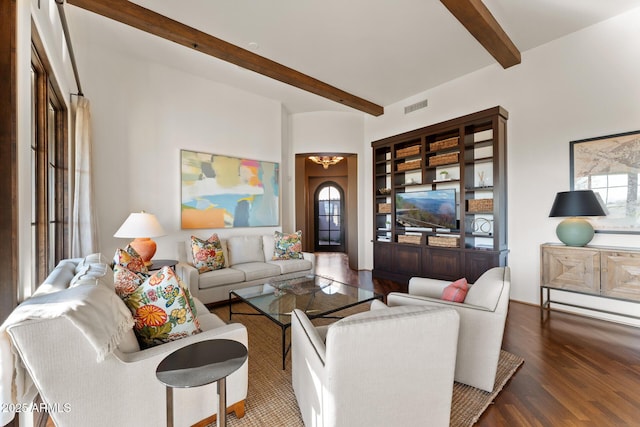 living area featuring plenty of natural light, visible vents, wood finished floors, a chandelier, and beam ceiling