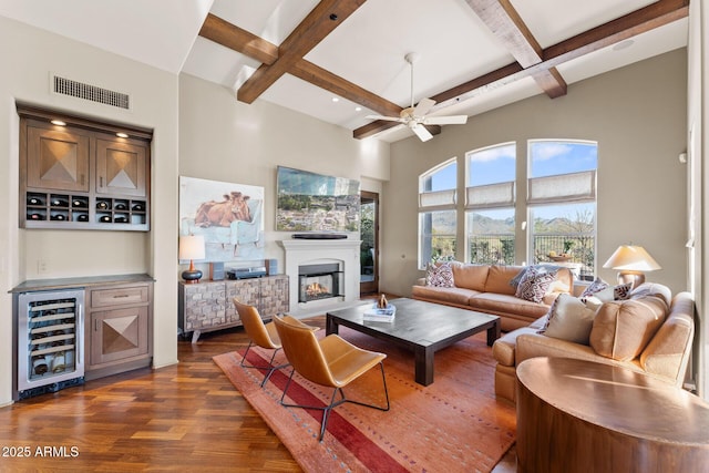 living room with beverage cooler, visible vents, coffered ceiling, a glass covered fireplace, and dark wood-style floors