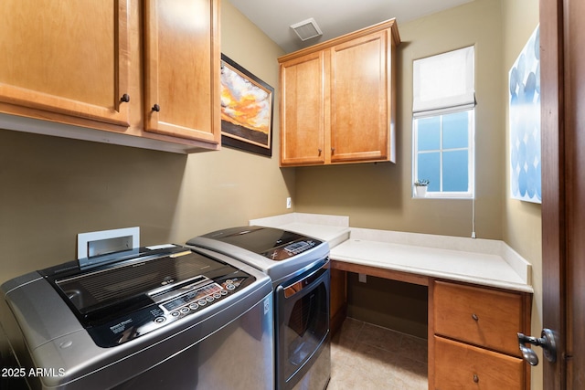 washroom with cabinet space, independent washer and dryer, visible vents, and light tile patterned floors