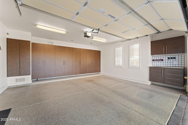 garage featuring visible vents and a garage door opener