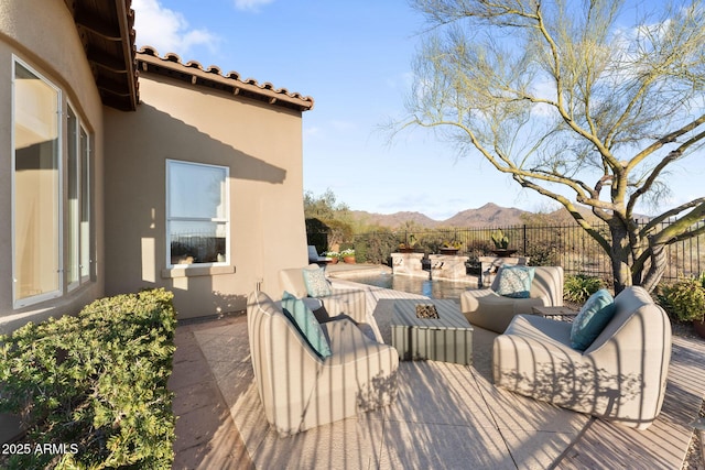 wooden terrace featuring outdoor lounge area, a patio area, fence, and a mountain view