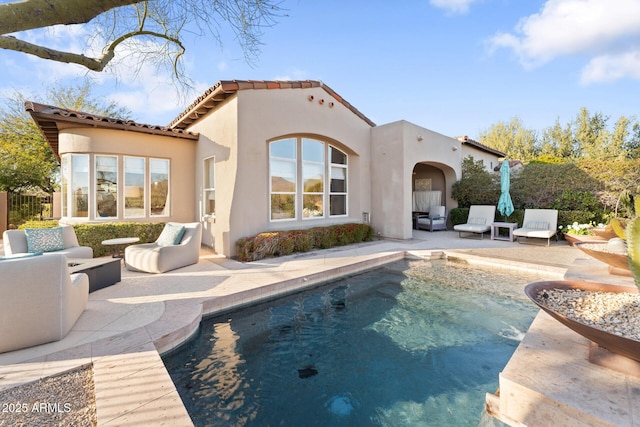 back of property featuring a patio, stucco siding, an outdoor hangout area, fence, and a tiled roof