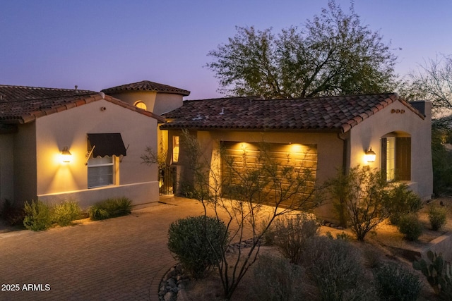 view of home's exterior with a garage, driveway, a tile roof, and stucco siding