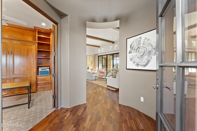 hall featuring beam ceiling and wood finished floors