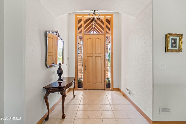 25509 S Lime Dr, Queen Creek, AZ 85142 - entrance foyer featuring baseboards, a textured wall, light tile patterned floors, visible vents, and arched walkways