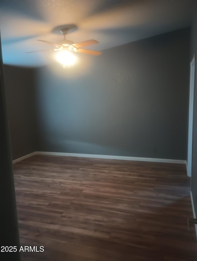 empty room with dark wood-type flooring and ceiling fan