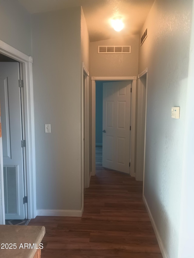 hallway with lofted ceiling and dark hardwood / wood-style floors