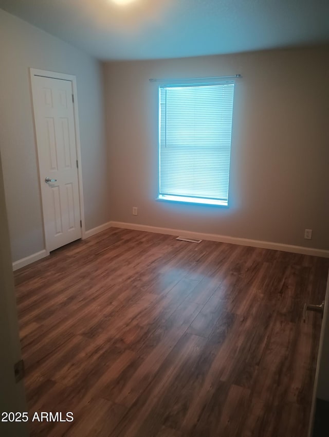 empty room featuring dark hardwood / wood-style flooring