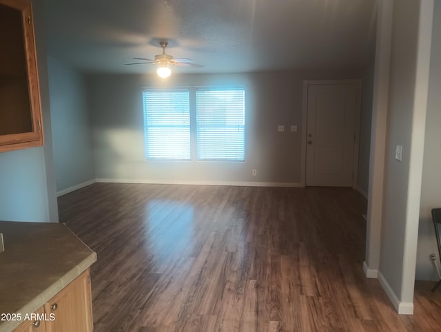 unfurnished living room featuring dark hardwood / wood-style flooring and ceiling fan