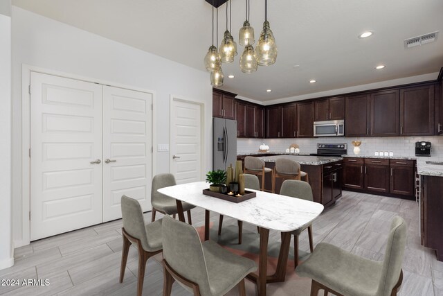 kitchen with a center island, sink, stainless steel appliances, and tasteful backsplash