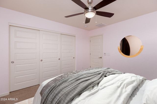 carpeted bedroom with ceiling fan and a closet