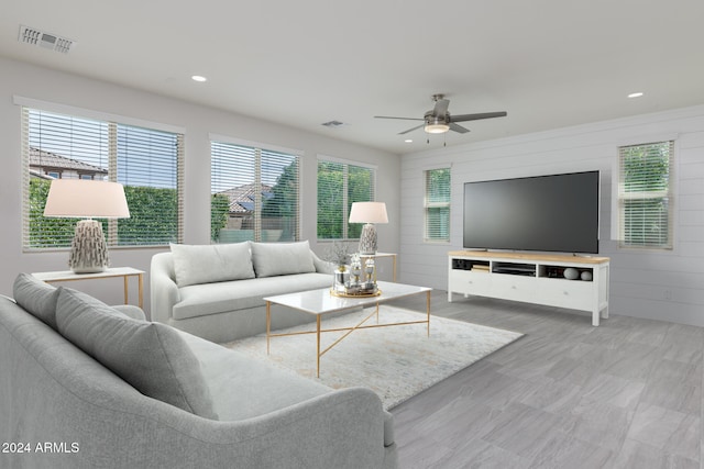 living room with ceiling fan and wooden walls