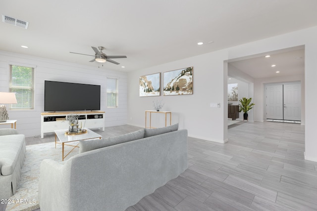 living room featuring ceiling fan, a wealth of natural light, and light hardwood / wood-style flooring