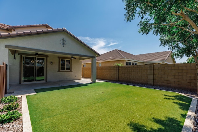 view of yard featuring ceiling fan and a patio