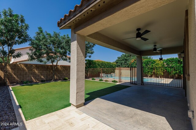 view of patio / terrace with ceiling fan and a fenced in pool