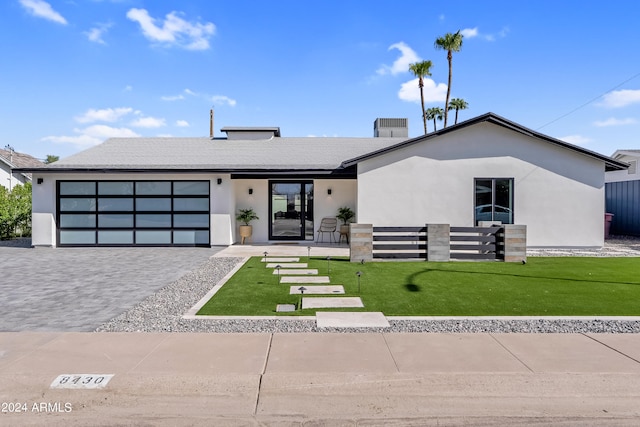 view of front of home with a garage and a front lawn