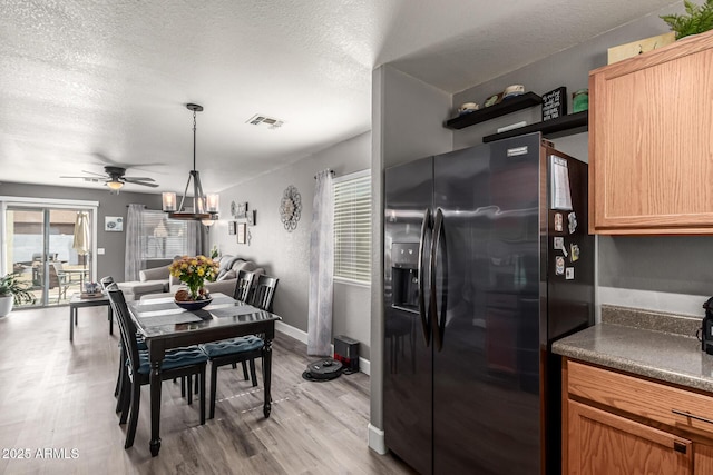 1950 E Dust Devil Dr, San Tan Valley, AZ 85143 - kitchen with black fridge with ice dispenser, wood finished floors, a ceiling fan, dark countertops, and a textured ceiling