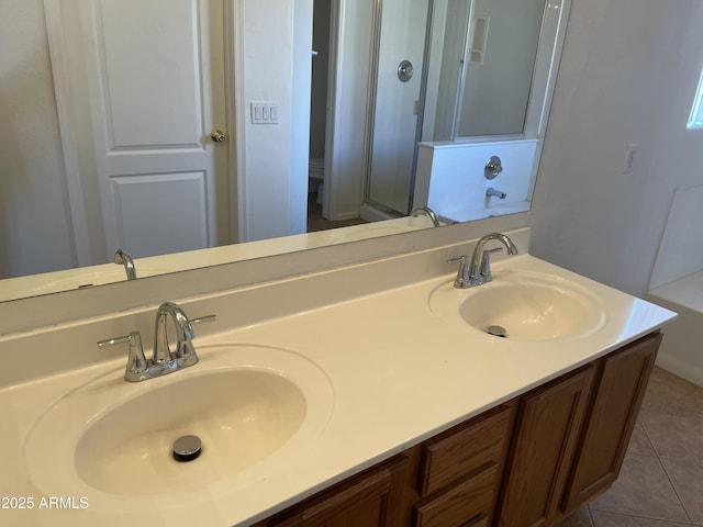 bathroom featuring double vanity, a stall shower, a sink, and tile patterned floors