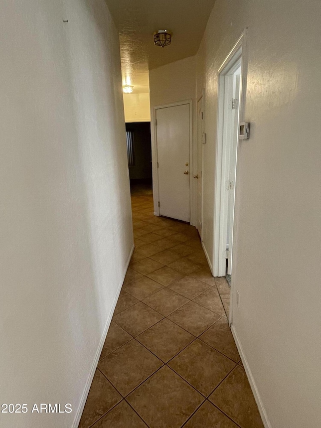 hall featuring baseboards and tile patterned floors