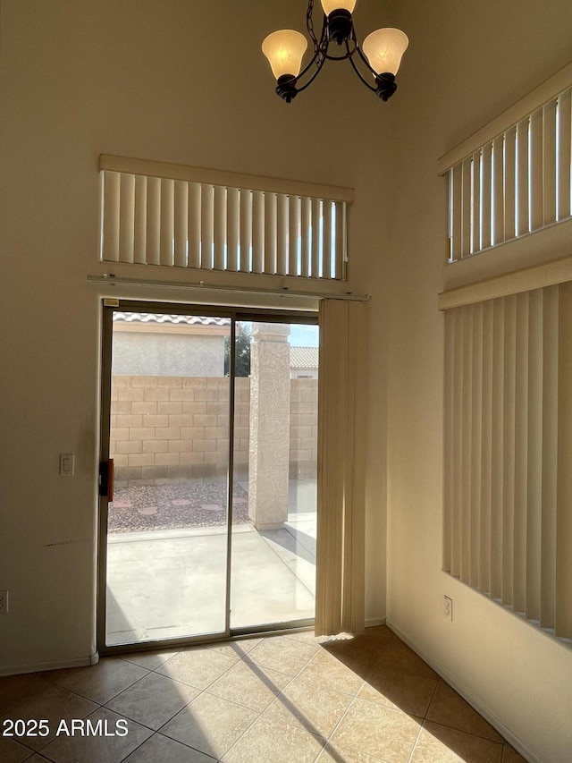 doorway to outside featuring an inviting chandelier and tile patterned flooring