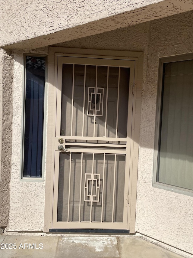 view of exterior entry featuring stucco siding