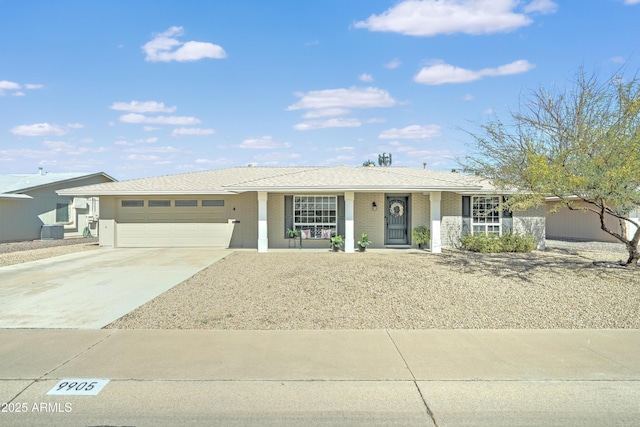 ranch-style house with brick siding, central AC unit, driveway, and a garage