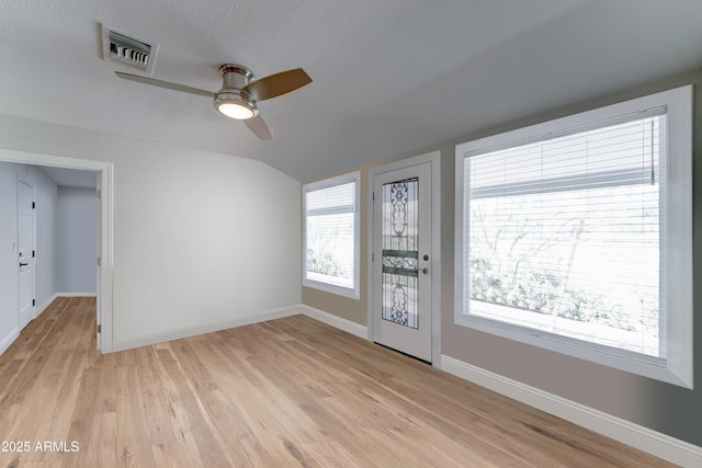 empty room with light wood-type flooring, visible vents, a healthy amount of sunlight, and ceiling fan