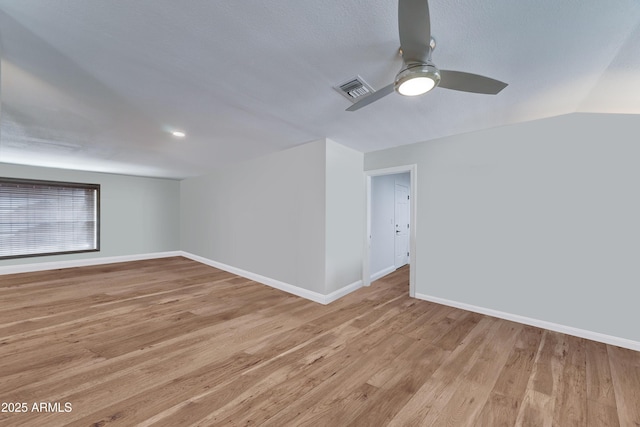 empty room featuring visible vents, light wood-style flooring, baseboards, and ceiling fan