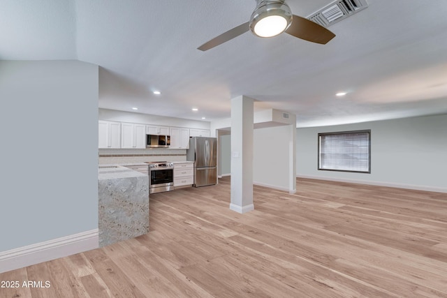 kitchen featuring visible vents, stainless steel appliances, white cabinets, light wood finished floors, and decorative backsplash