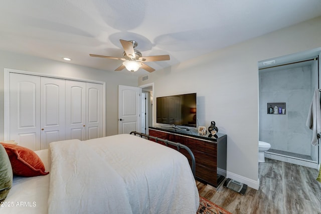 bedroom with visible vents, a ceiling fan, wood finished floors, a closet, and baseboards