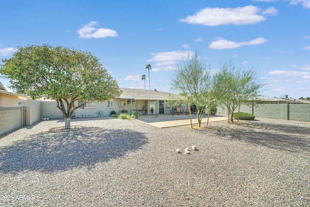 rear view of house featuring a fenced backyard and a patio area