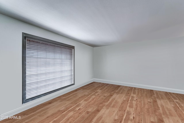 unfurnished room with light wood finished floors and baseboards