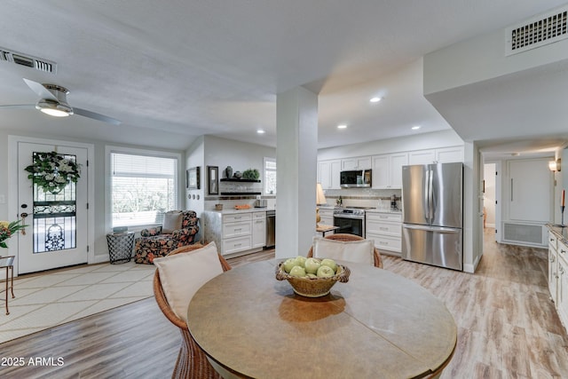 dining area featuring recessed lighting, visible vents, and light wood-type flooring