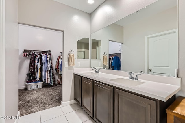 23730 W Hess Ave, Buckeye, AZ 85326 - bathroom with a walk in closet, double vanity, baseboards, and tile patterned floors