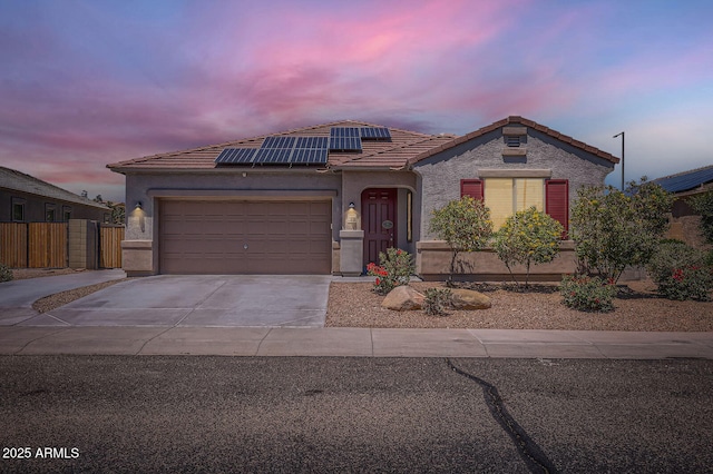 23730 W Hess Ave, Buckeye, AZ 85326 - view of front facade featuring a tile roof, concrete driveway, solar panels, a garage, and stucco siding