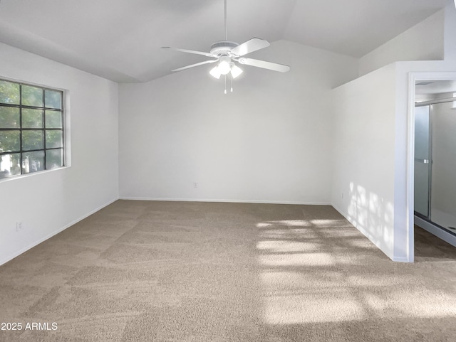 carpeted spare room featuring ceiling fan and lofted ceiling