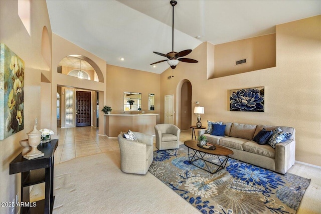 carpeted living room featuring ceiling fan and high vaulted ceiling