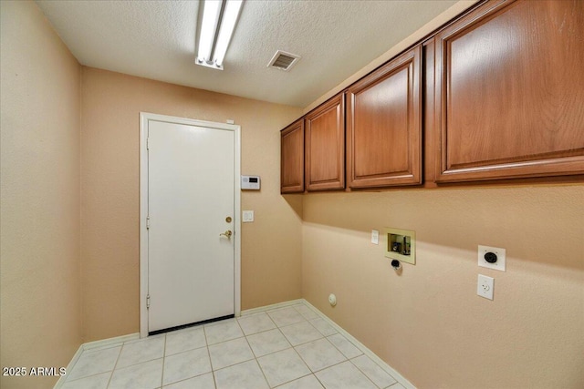 laundry area featuring light tile patterned floors, electric dryer hookup, hookup for a washing machine, cabinets, and a textured ceiling