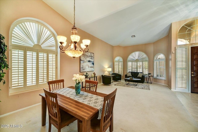 carpeted dining area with a wealth of natural light, a notable chandelier, and high vaulted ceiling