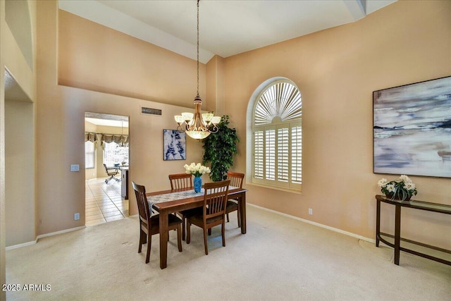 carpeted dining room featuring a wealth of natural light and a chandelier