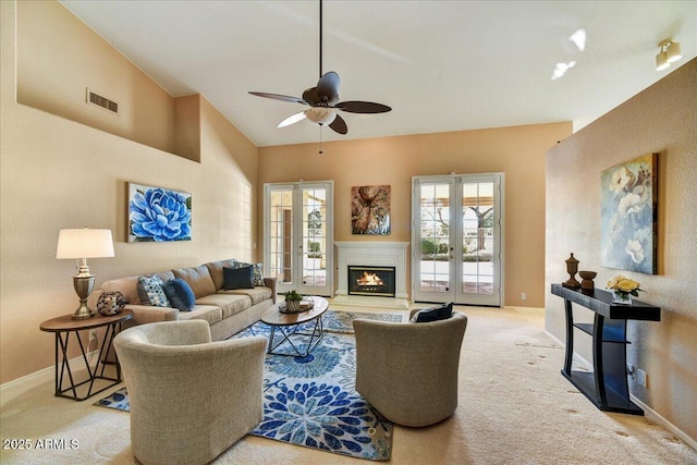 carpeted living room with lofted ceiling, french doors, and ceiling fan