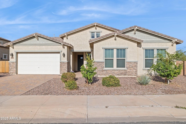 craftsman house featuring decorative driveway, stone siding, an attached garage, and stucco siding